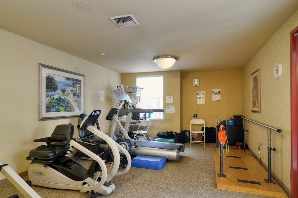 Small fitness room with treadmills and exercise bikes.