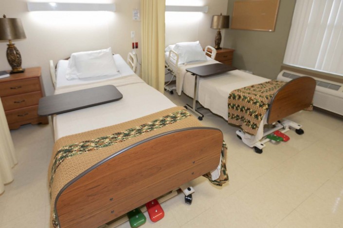 A clean hospital room with two beds separated by a curtain.