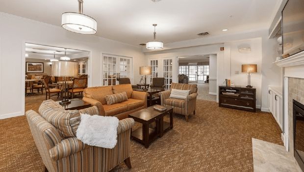 A spacious and elegantly furnished living room with comfortable seating arrangements and modern lighting.