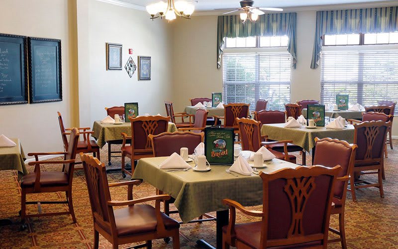 A cozy dining room setup with neatly arranged tables and chairs.