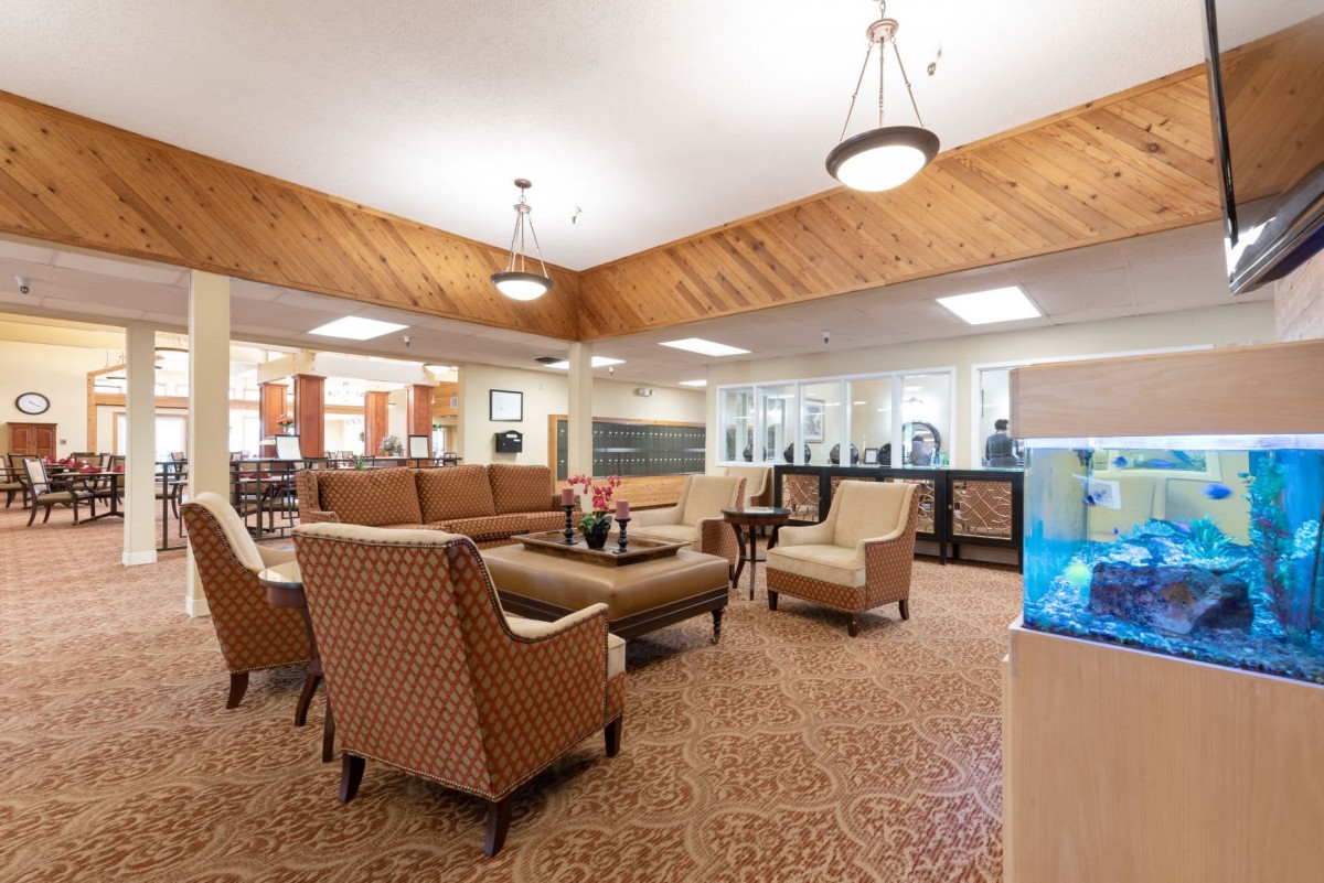 A cozy lobby area featuring comfortable seating with sofas and chairs, illuminated by soft overhead lighting.