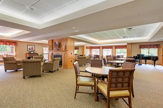 A spacious and well-lit lounge area with comfortable seating and a fireplace.