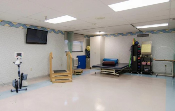 A rehabilitation room equipped with various physical therapy tools and exercise equipment.