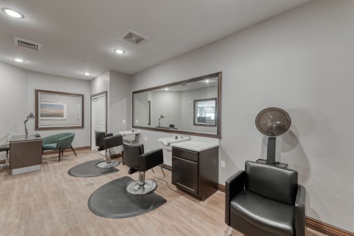 A modern and clean salon interior with styling chairs and large mirrors.
