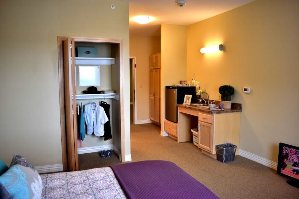 A modern and cozy bedroom with an open closet and well-organized furniture.