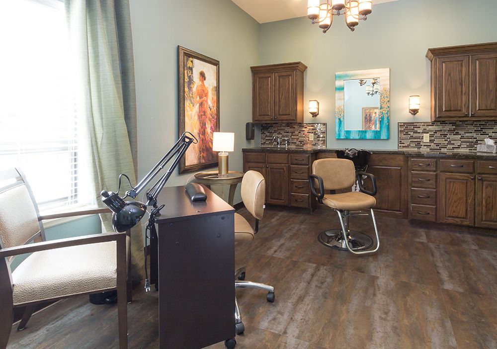 A well-organized salon room with stylish decor, featuring a styling chair, desk, and artwork.
