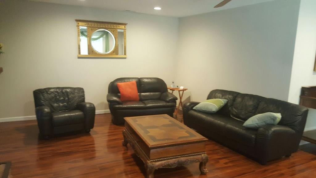 A cozy living room with leather sofas and a wooden coffee table.
