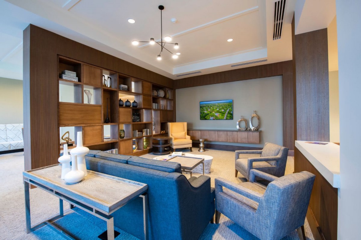A modern living room featuring sleek furniture, built-in bookshelves, and stylish lighting.