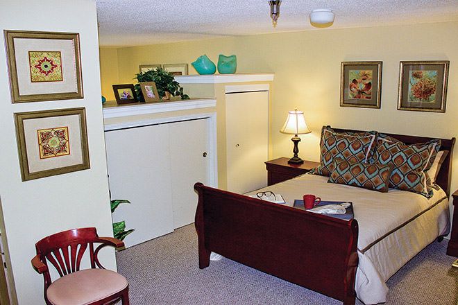 A cozy bedroom with a sleigh bed, bedside lamp, and decorative elements.