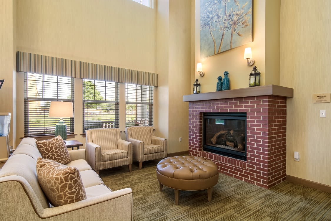 A cozy living room with modern decor, featuring a brick fireplace and comfortable seating.