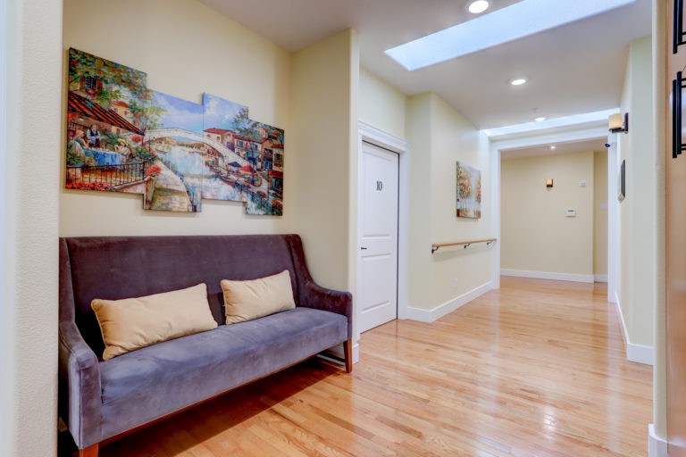 A bright hallway with a comfortable sofa and artwork on the walls.