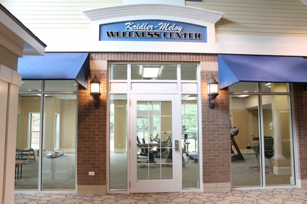 The entrance of a wellness center with fitness equipment visible inside.