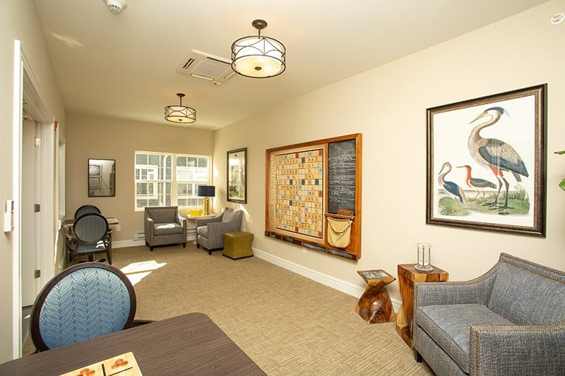 A cozy living room with comfortable seating, artwork on the walls, and ample natural light.
