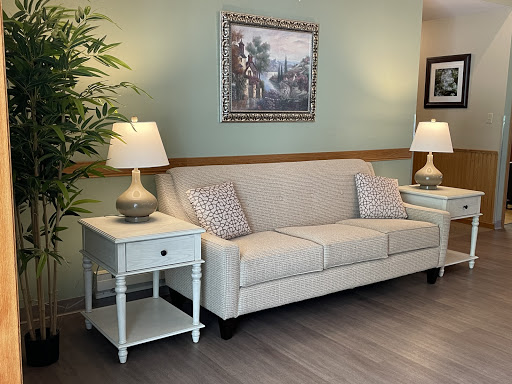 A cozy living room setup featuring a light-colored sofa, stylish lamps, and elegant artwork.