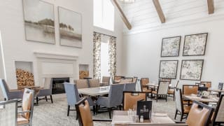 A spacious and elegantly designed restaurant interior with high ceilings and modern furnishings.