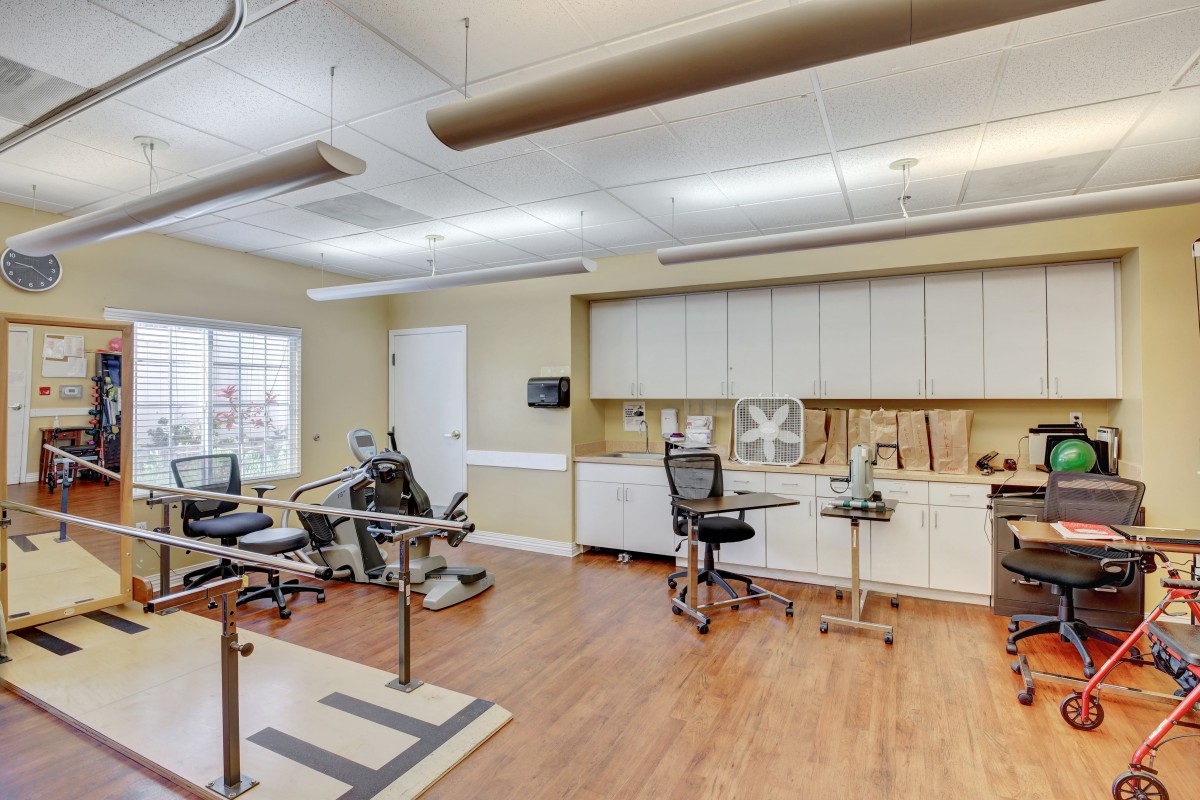 A physical therapy room equipped with exercise machines and supplies, designed for rehabilitation and healthcare activities.