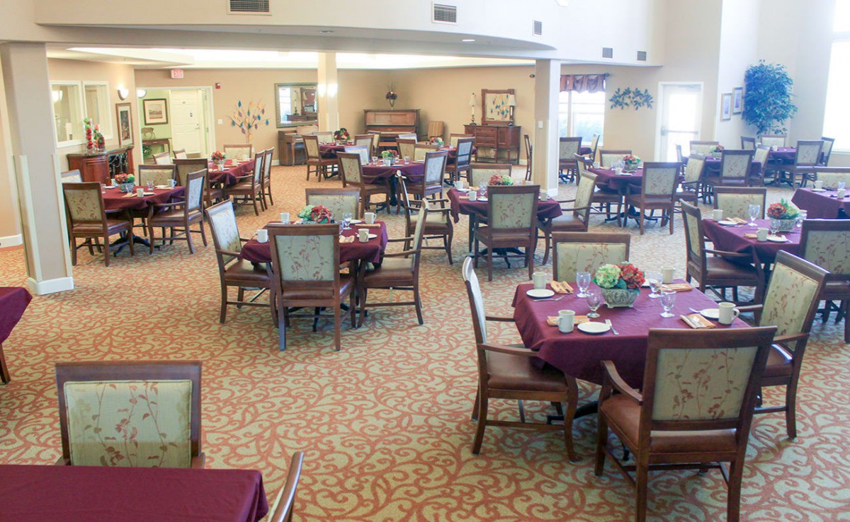An empty dining area with neatly arranged tables and chairs, ready for guests.