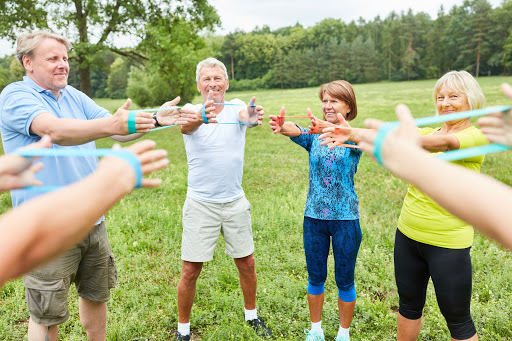 A group of people engaging in a fitness activity outdoors, promoting health and wellness.