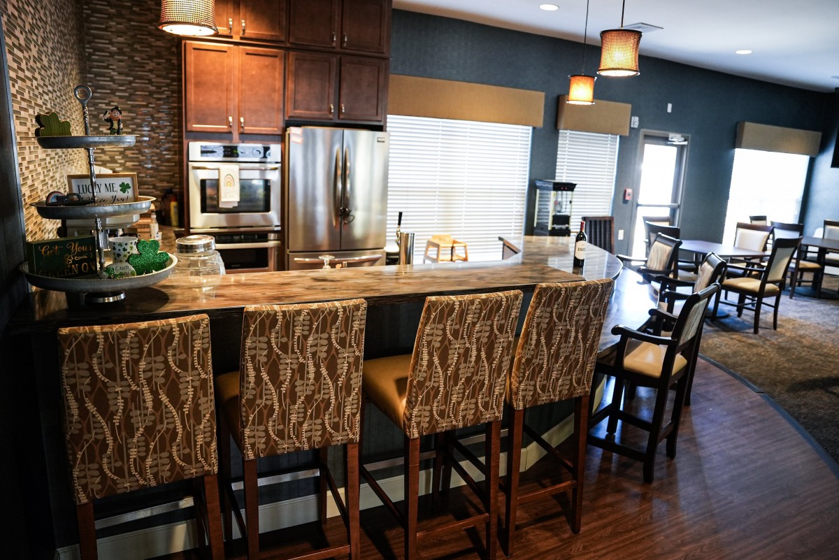 A modern kitchen interior featuring a stylish countertop with bar stools and stainless steel appliances.