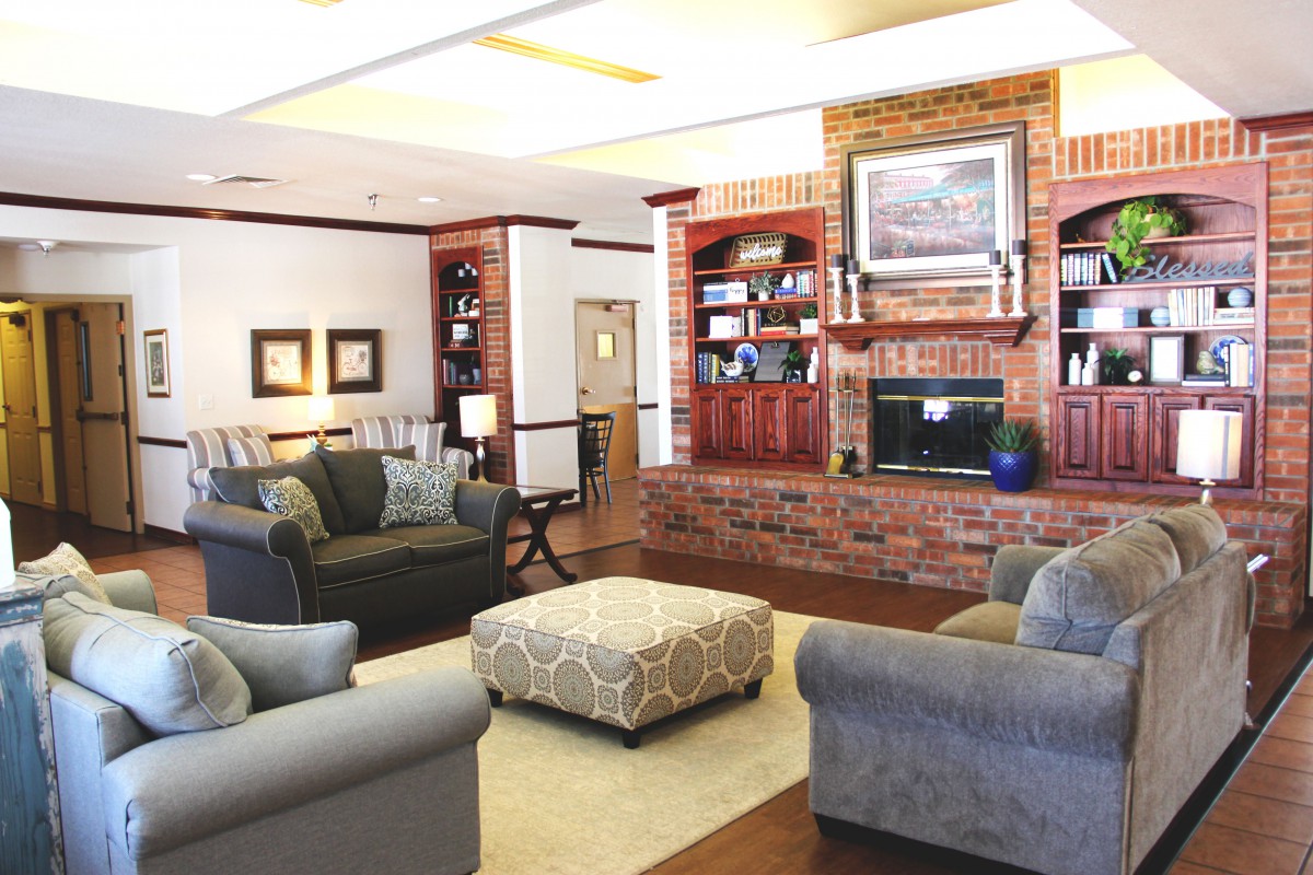 A cozy living room featuring a fireplace, comfortable couches, and built-in bookshelves.