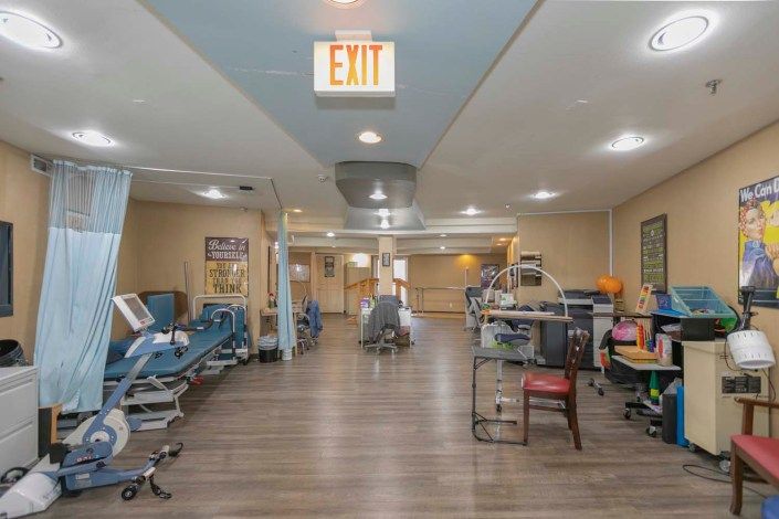 A hospital corridor with medical equipment and a wheelchair.