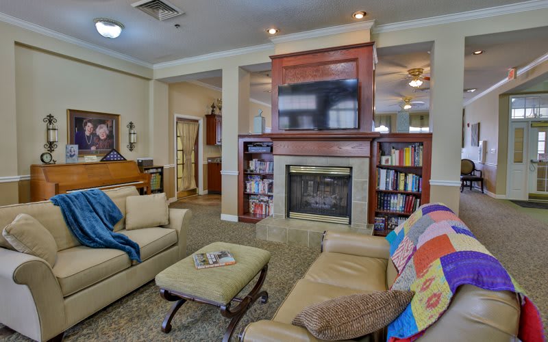 A cozy living room featuring a fireplace, bookshelves, and comfortable seating.