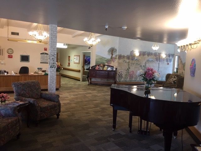 A cozy lobby interior featuring a grand piano and comfortable seating.