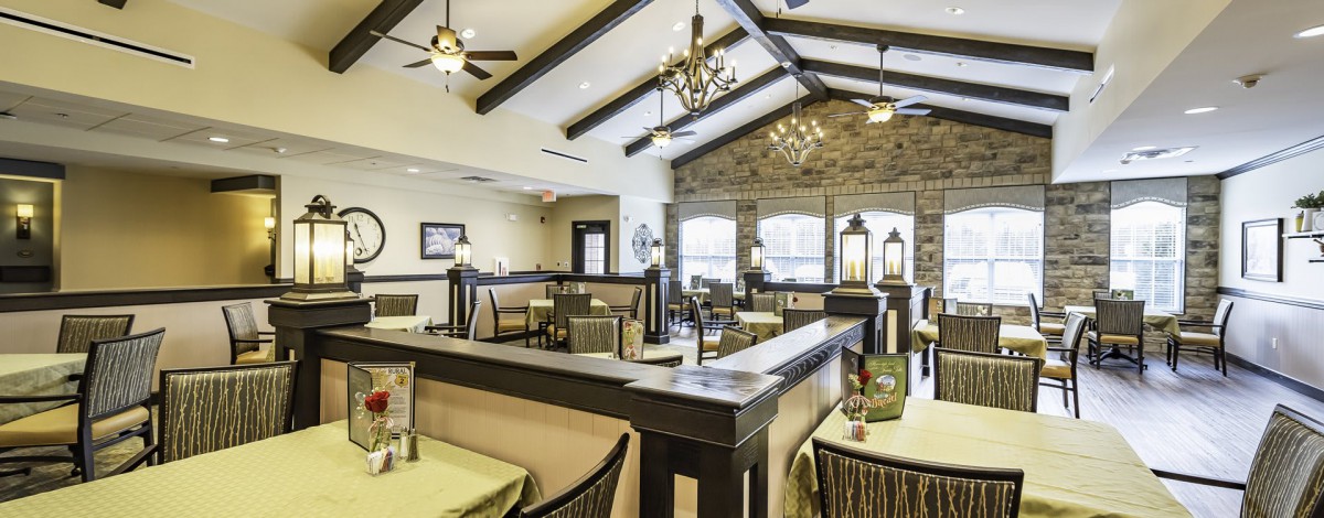 A modern restaurant interior with tables and chairs arranged in a spacious dining area.