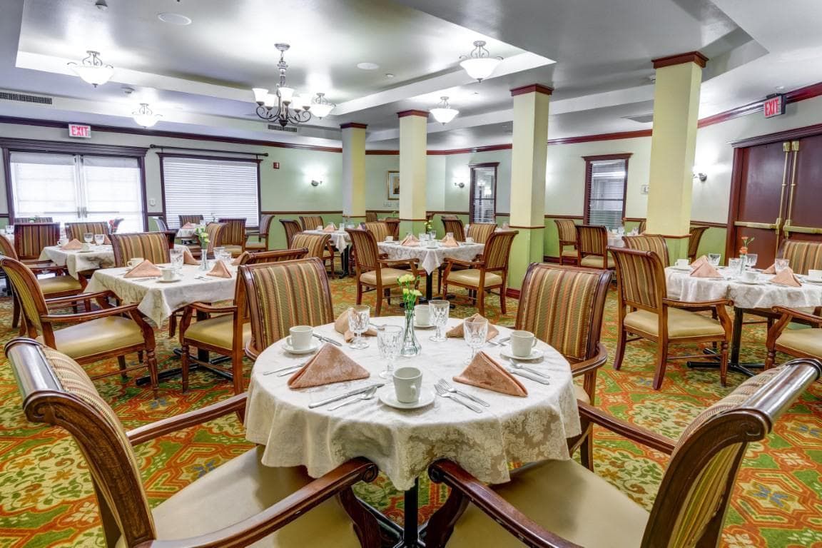 An elegant restaurant dining room with neatly arranged tables and chairs.