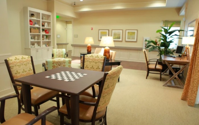 A cozy living room with a seating area, chessboard table, and tasteful decor.
