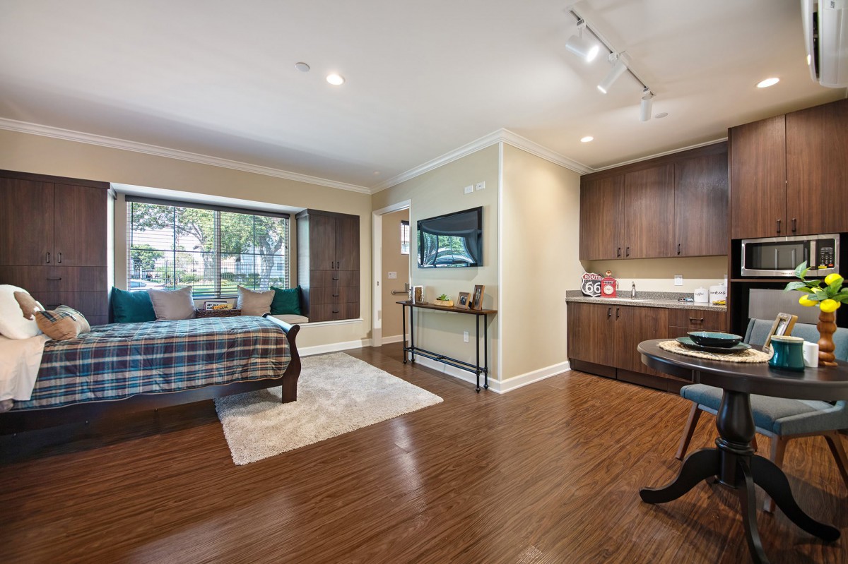 Spacious bedroom with wooden floors, cozy seating area, and ample natural light.