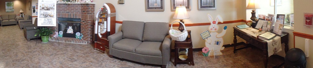A cozy living room corner featuring a gray sofa, side table with a lamp and decorative basket.