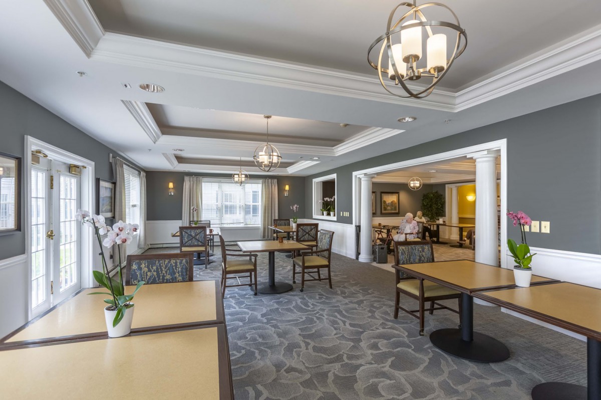 A spacious and elegantly designed dining area with modern furniture and lighting.