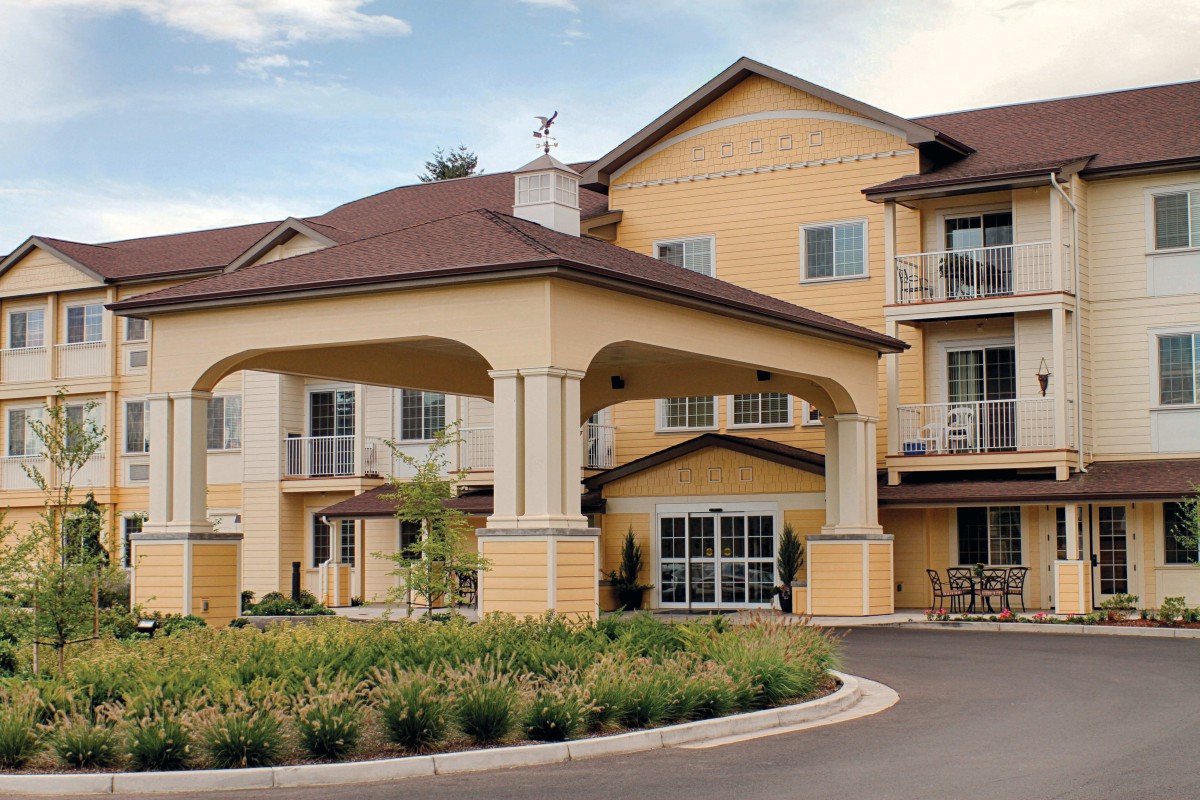 A well-maintained residential building with a covered entrance and landscaped surroundings.