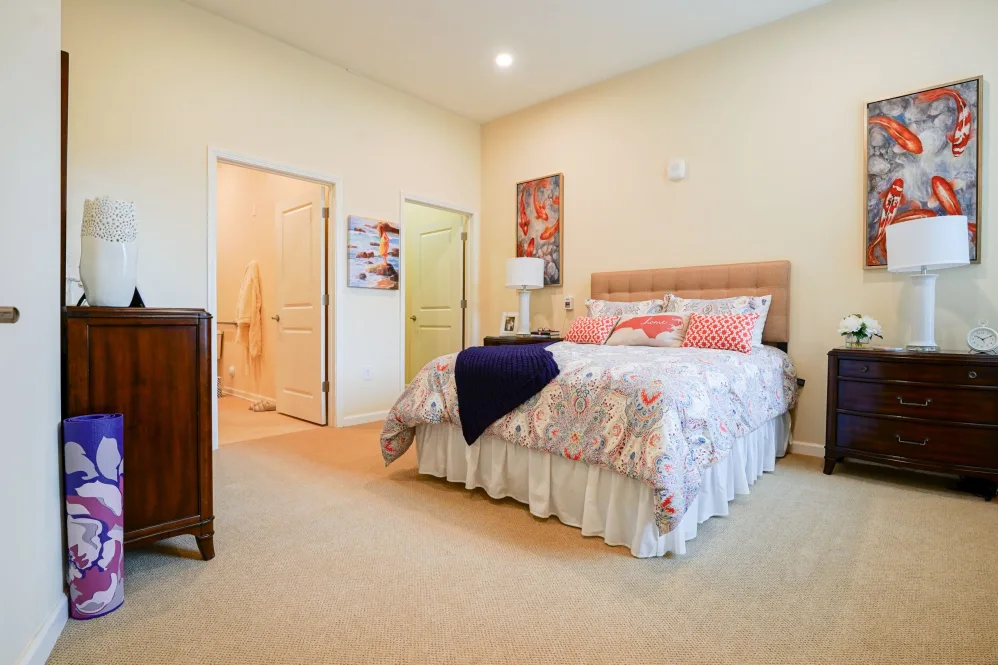 A cozy bedroom with a neatly made bed, soft lighting, and warm decor.