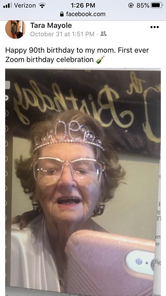 An elderly woman wearing a tiara and glasses celebrating her birthday.
