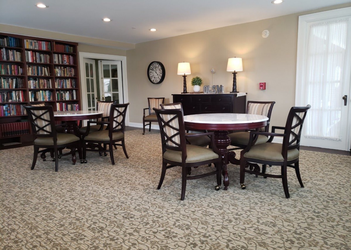 Cozy library seating area with round tables and bookshelves.