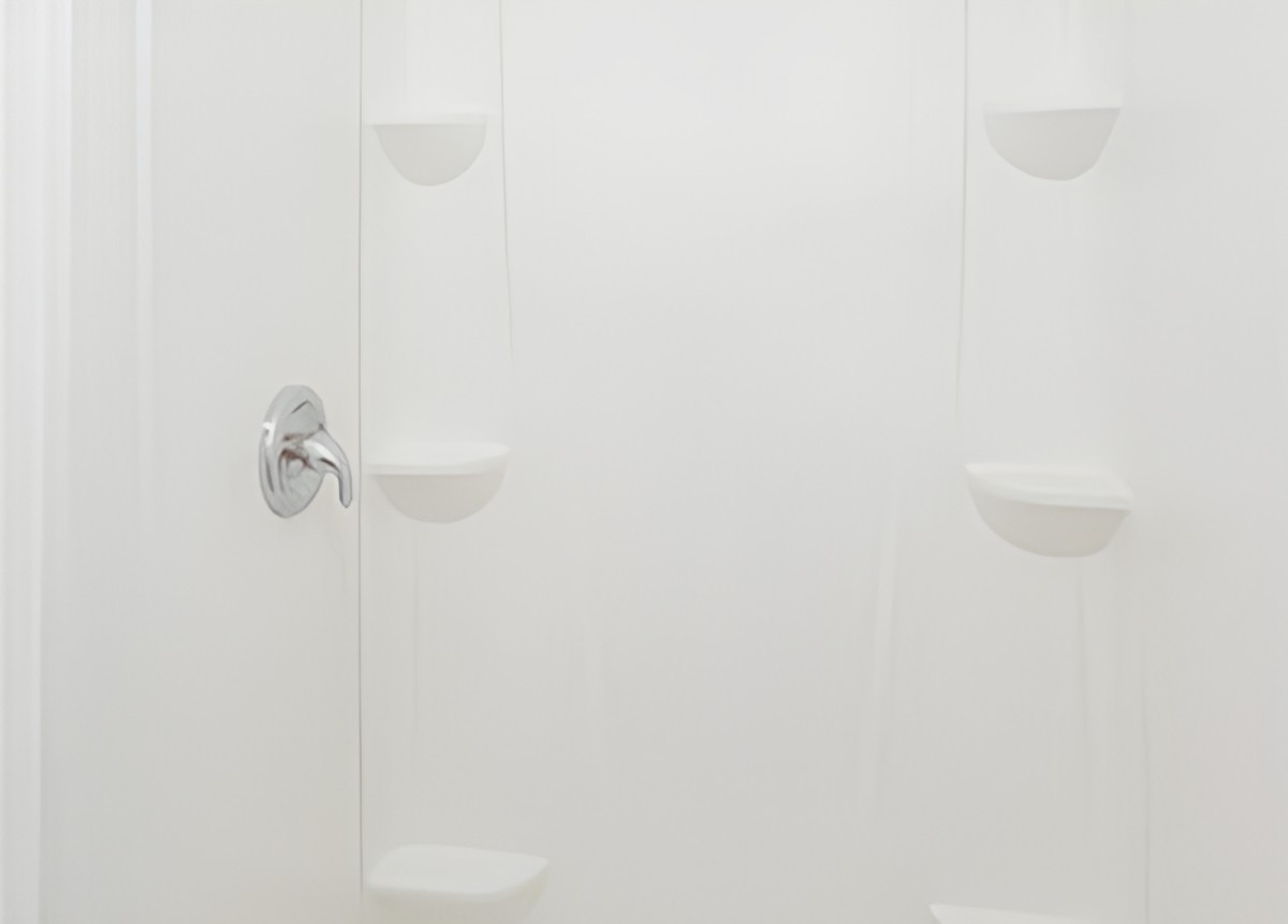 A minimalist white shower area with built-in shelves and a chrome faucet.