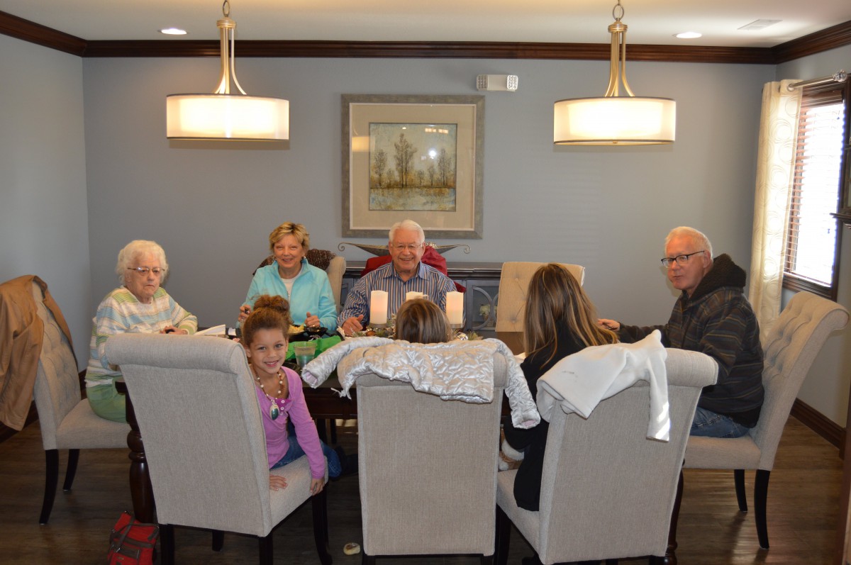 A family gathered around the dining table sharing a meal.