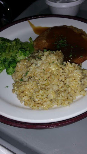 A plate featuring fluffy rice, steamed broccoli, and a savory side dish.