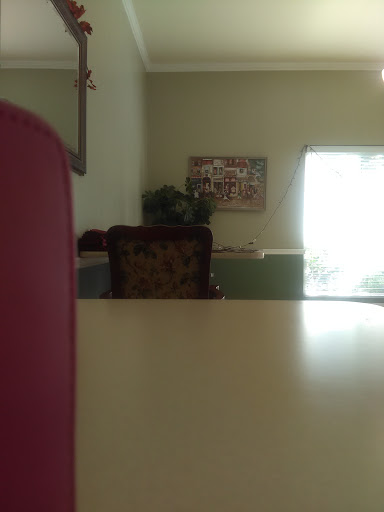 A cozy and simple interior view featuring a table, chair, and softly lit window.