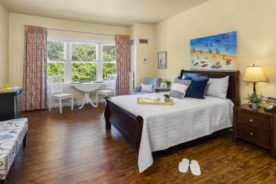 A bright and cozy hotel room with elegant furniture and a large window letting in plenty of natural light.