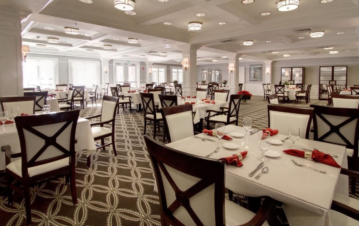 An elegantly set dining room with neatly arranged tables and chairs.