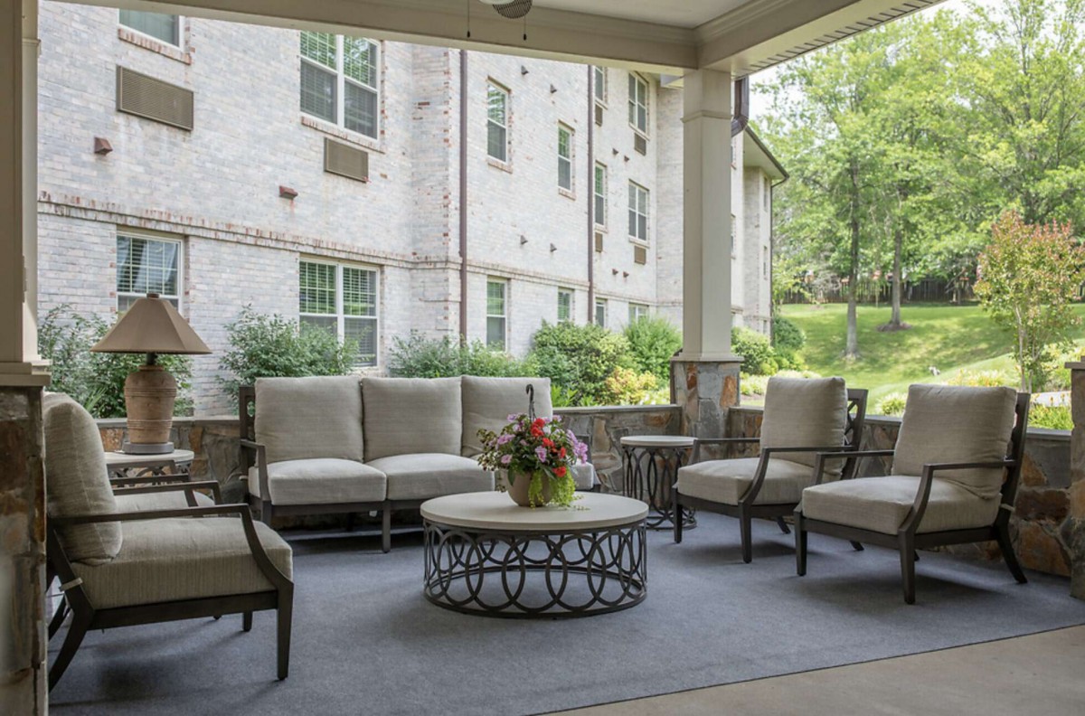 A serene outdoor patio featuring comfortable seating and a decorative table, perfect for relaxation.