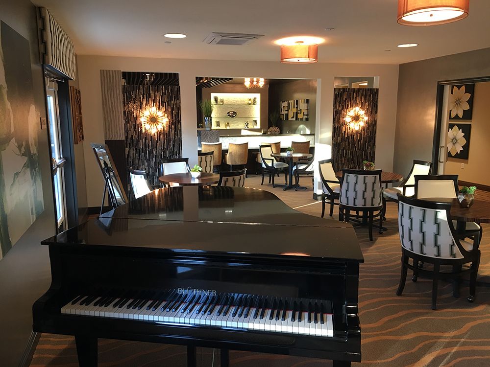 A cozy lounge area featuring a grand piano and elegant dining setup.