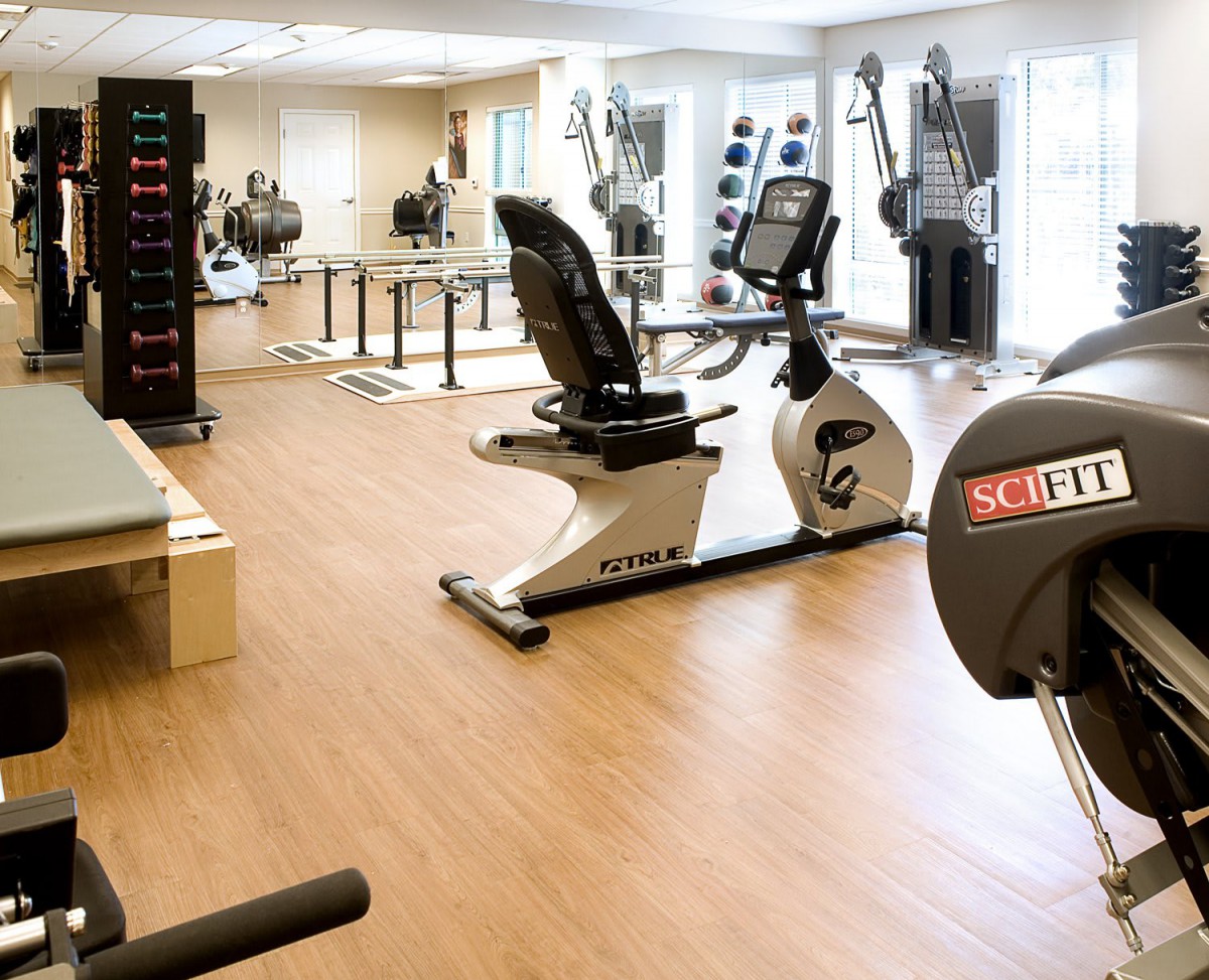 A modern gym with various exercise equipment and cardio machines.