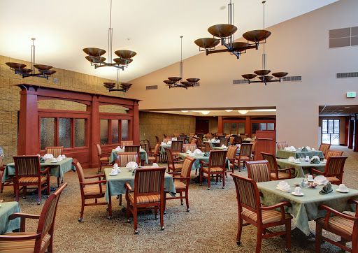A spacious and elegantly designed dining area featuring wooden furniture and unique lighting fixtures.