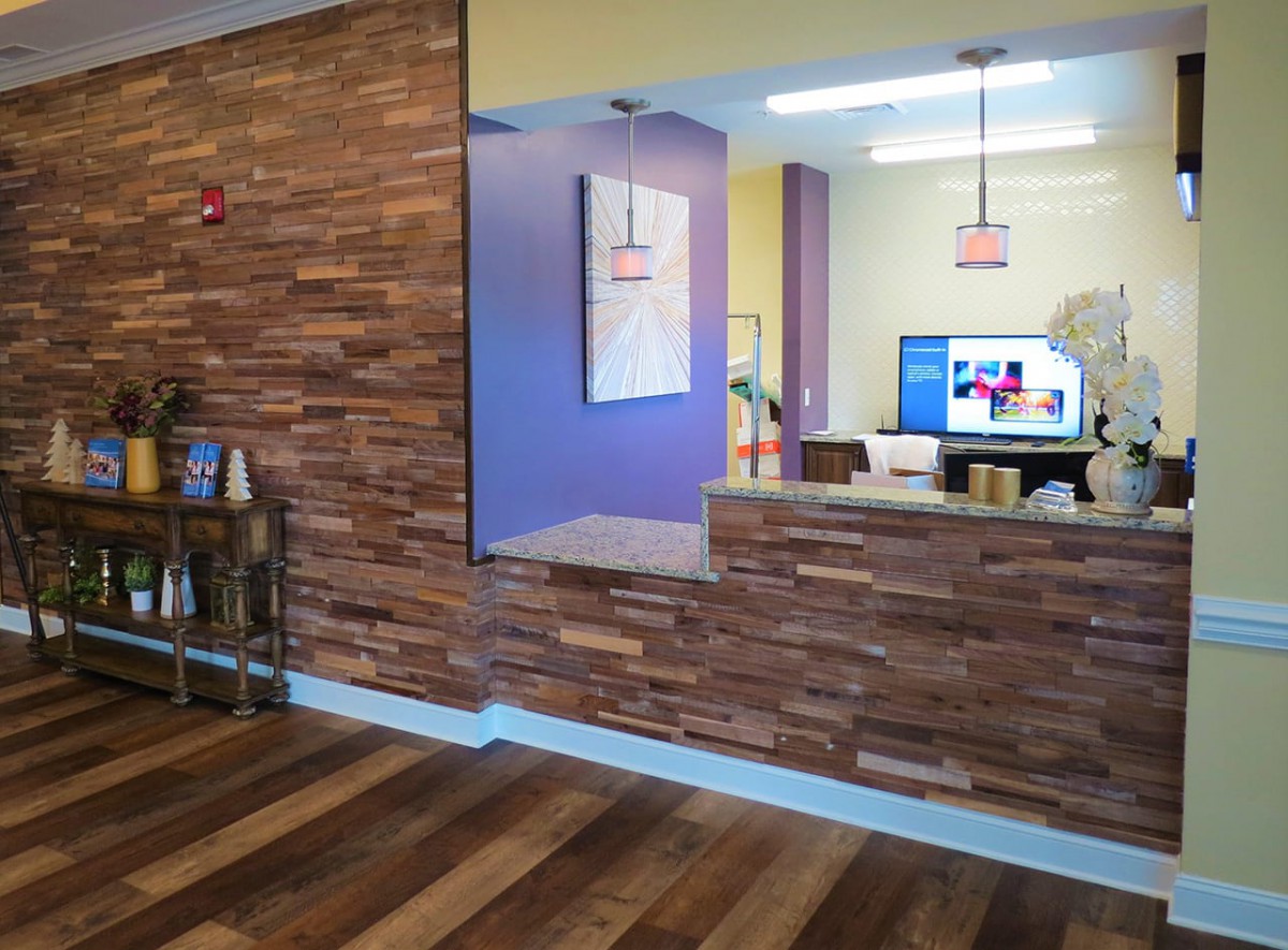 A modern reception area featuring wood paneling and a comfortable waiting space.