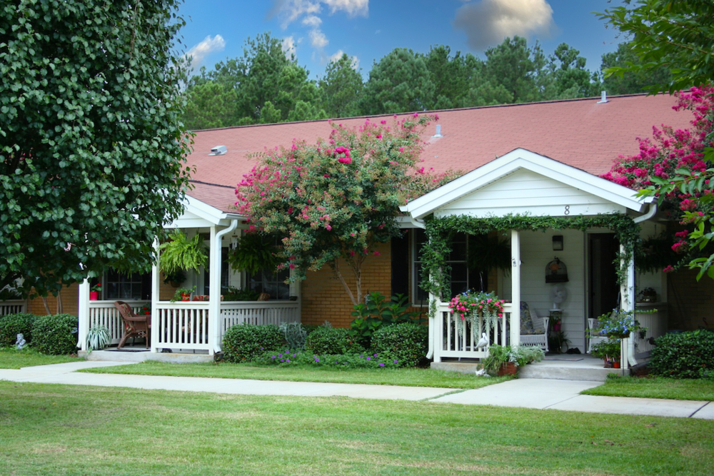 A charming house with a porch and well-maintained garden.