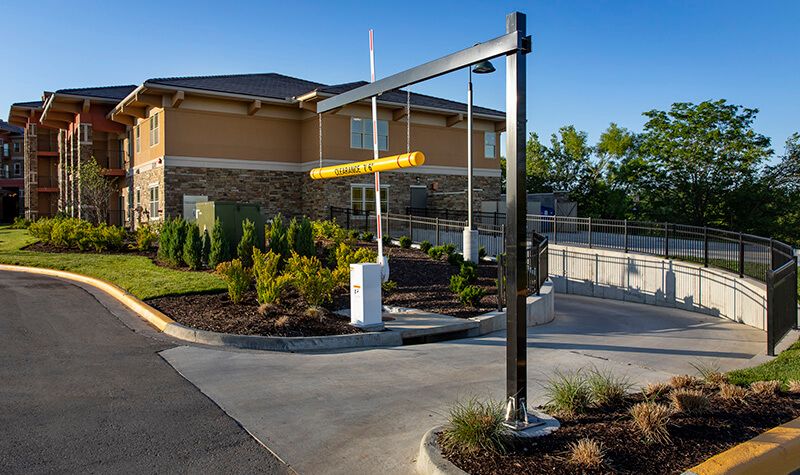 A drive-thru lane with a height restriction bar near a restaurant building.